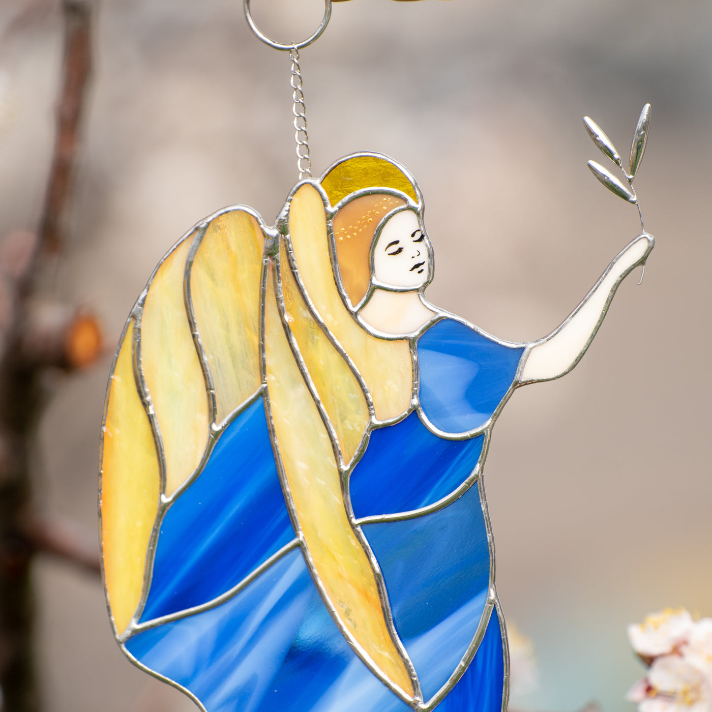 Zoomed stained glass guardian angel with yellow wings wearing a blue dress
