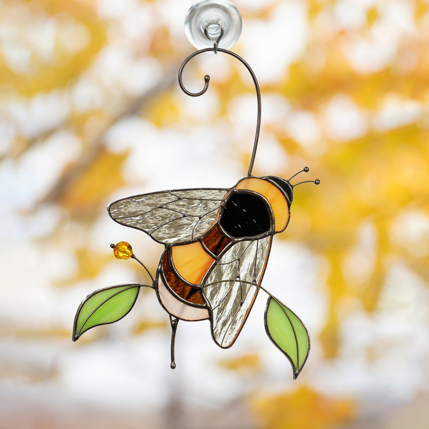 Bumble bee with green leaves and iridescent wings suncatcher of stained glass