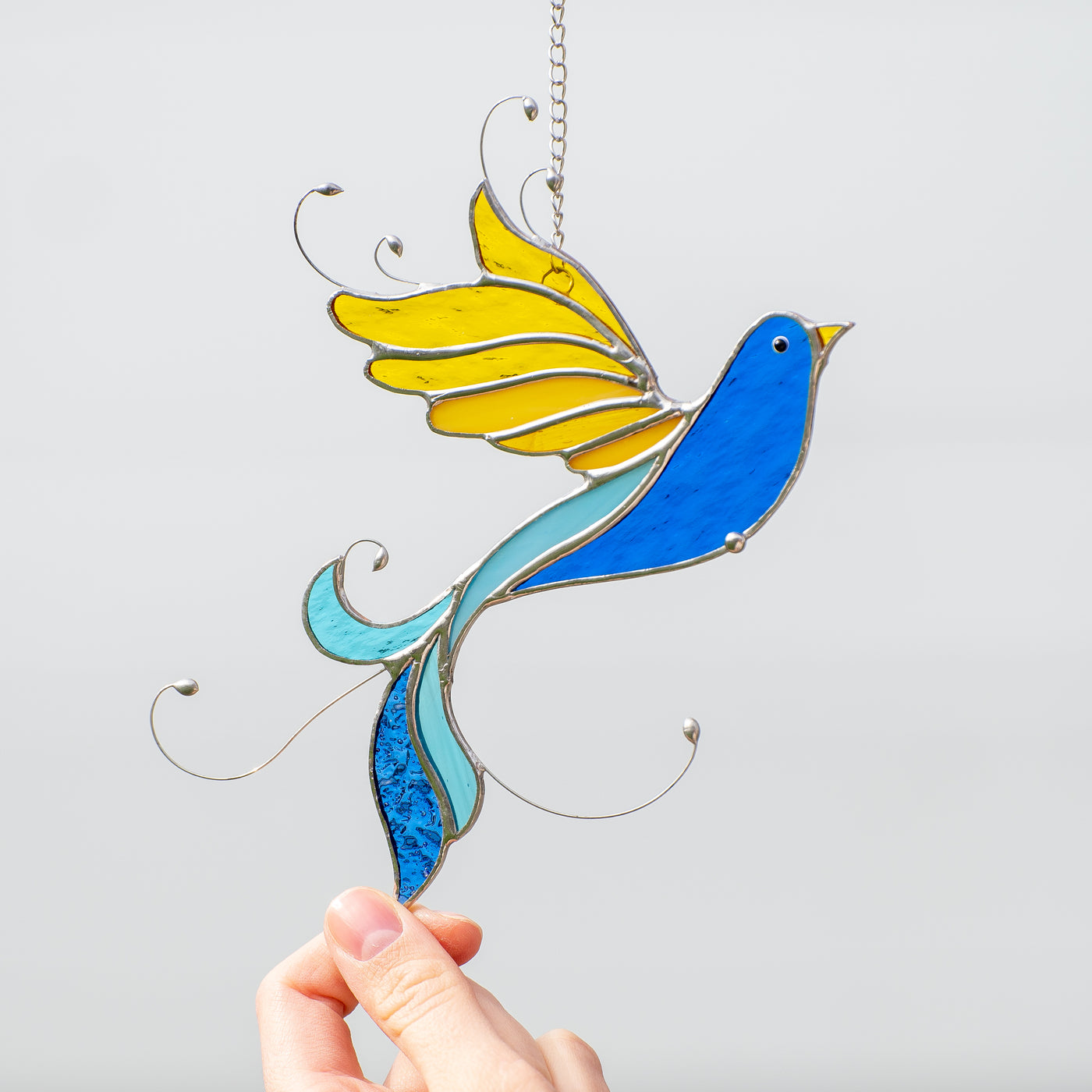 Stained glass bird of blue and yellow colors sucnatcher