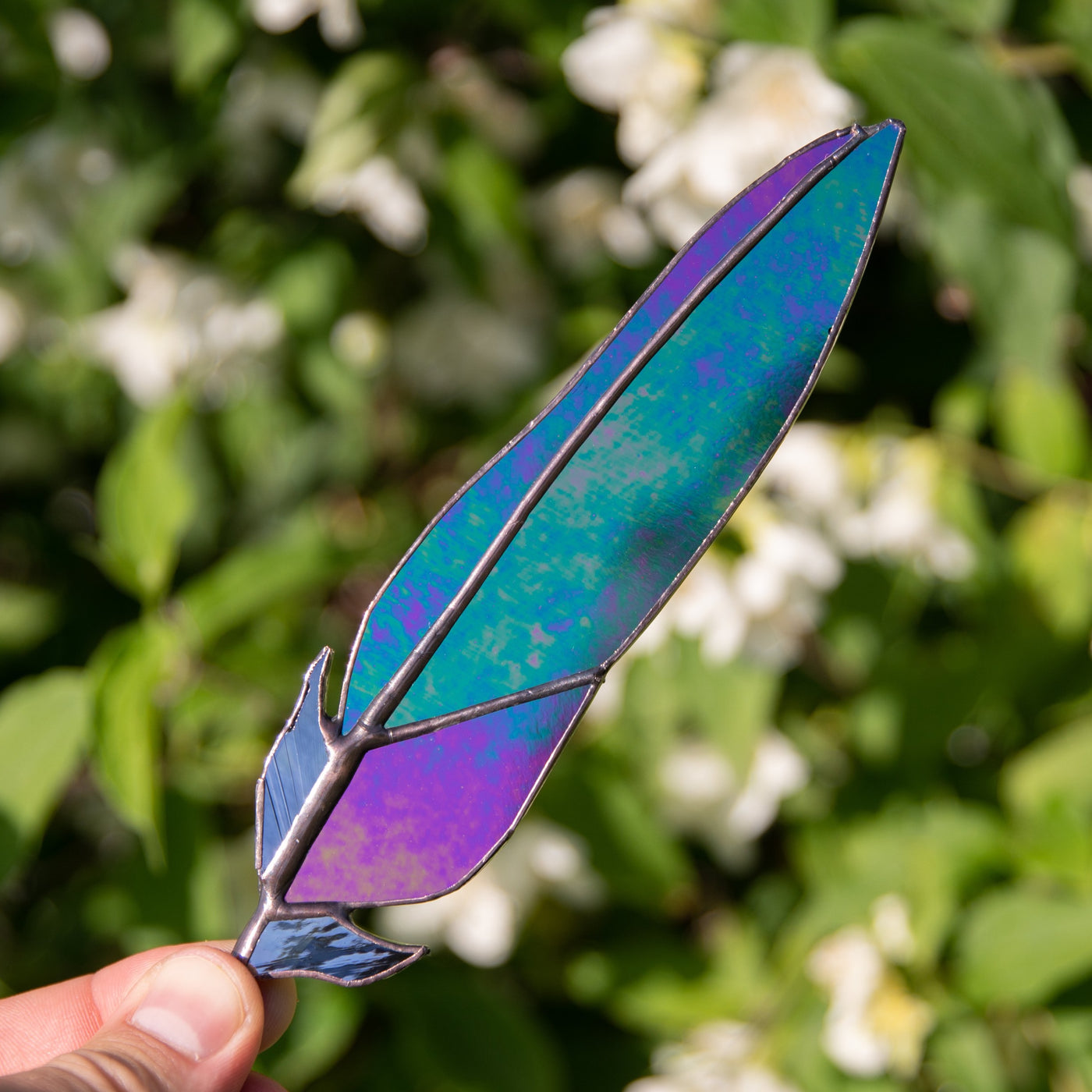 Stained glass raven feather with modulating colours suncatcher