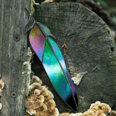 Suncatcher of a stained glass raven feather with modulating colours