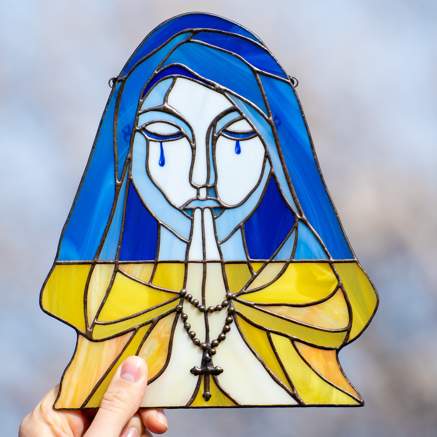 Praying and crying woman symbolising Ukraine window panel of stained glass