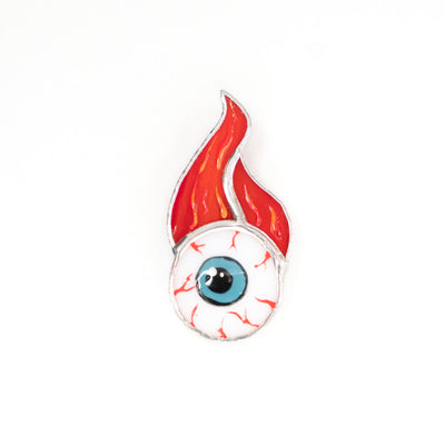 Torn out eye with fire above brooch of stained glass 