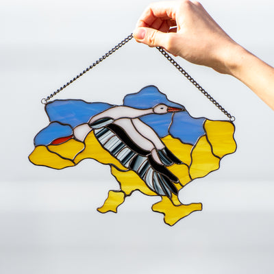 The map of Ukraine with the flying stork in the middle window panel of stained glass
