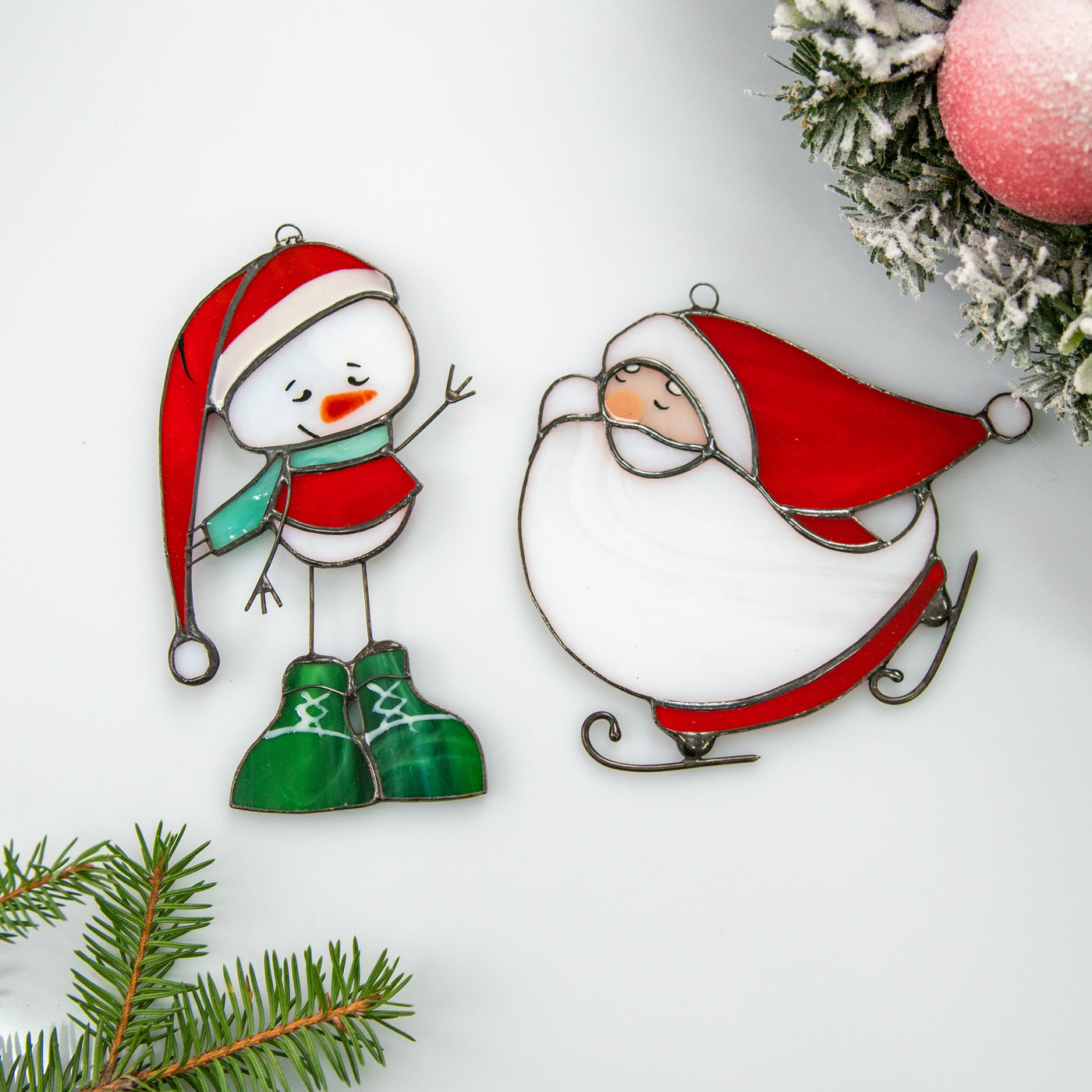 Two stained glass suncatchers of a snowman and santa  Edit alt text