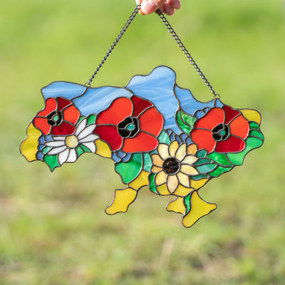 Stained glass window panel in the shape of Ukrainian map with flowers inside of it 