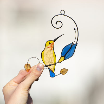 Stained glass yellow hummingbird with blue flower suncatcher