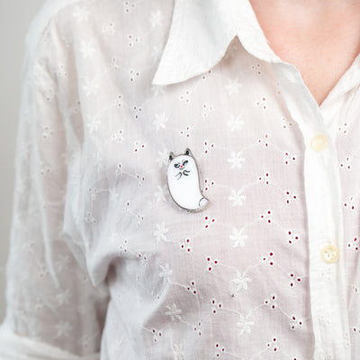Cat ghost brooch of stained glass on a white shirt