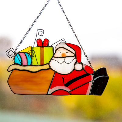 Stained glass Santa lying next to the gifts suncatcher 