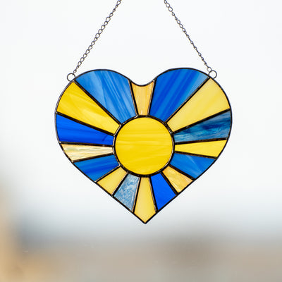 Stained glass window hanging of Ukrainian heart with the sun-rays inside 
