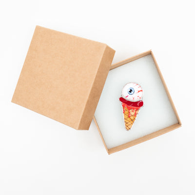 Ice-cream with the torn out eye brooch in a brand box