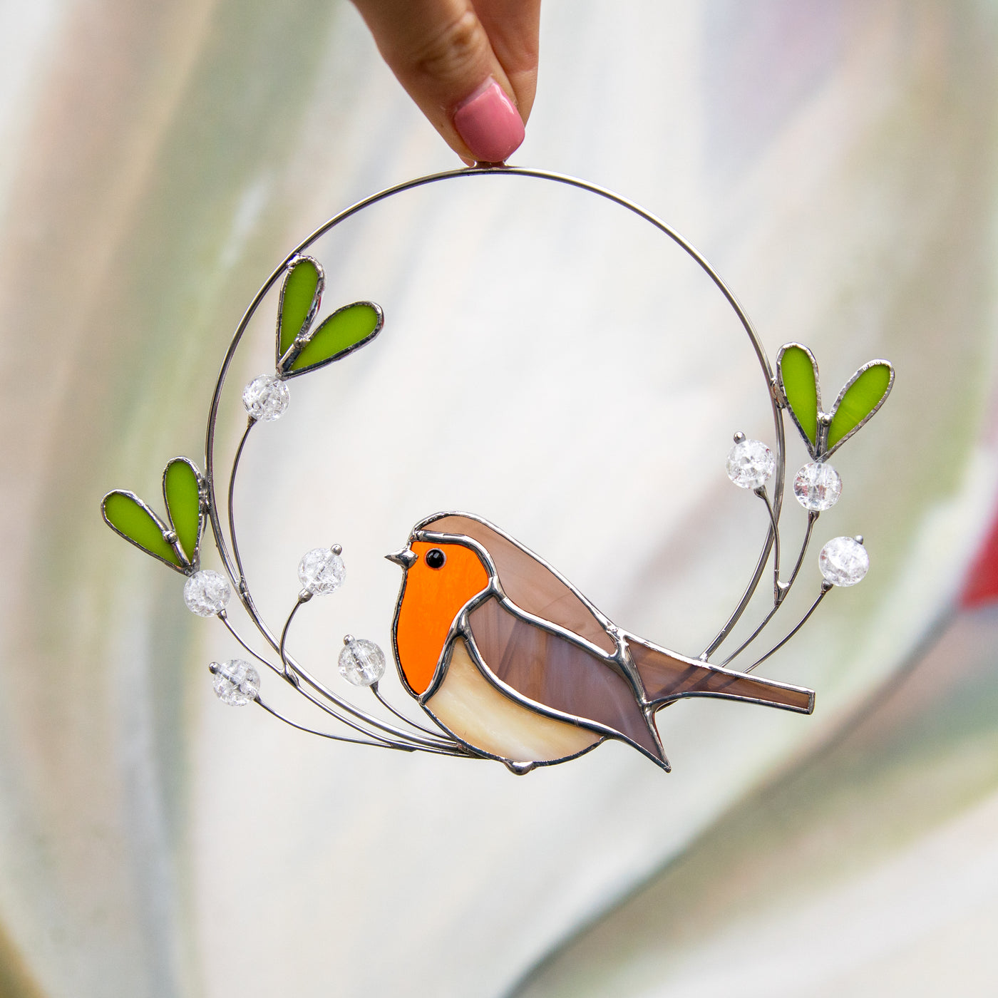 Stained glass robin sitting on the mistletoe suncatcher 