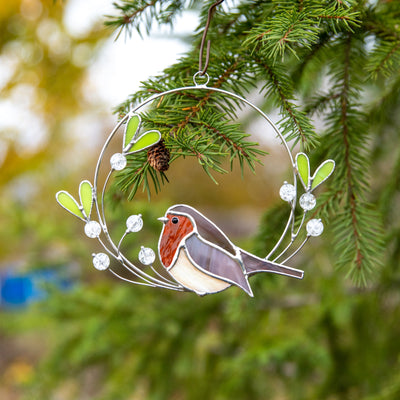 Stained glass robin on the mistletoe suncatcher used as a New Year Tree decoration