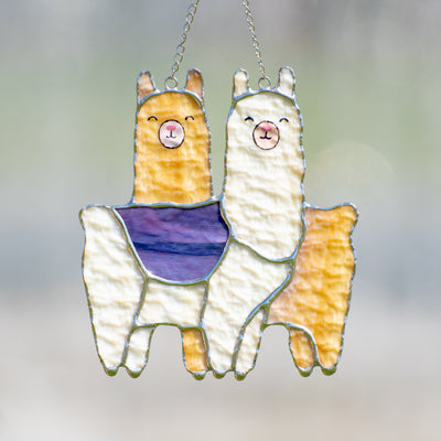 Stained glass couple of white and orange llamas standing across each other suncatcher