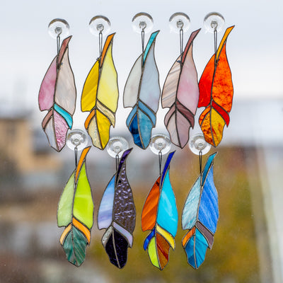 The collection of colourful stained glass feather suncatchers