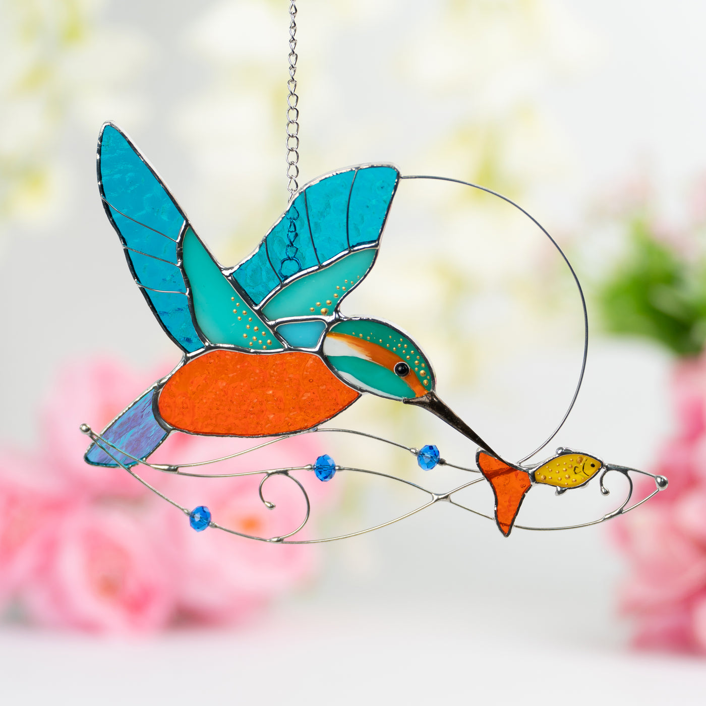 Stained glass suncatcher of a kingfisher bird with the fish