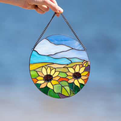Round panel depicting sunflowers and sky of stained glass