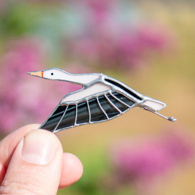 Zoomed stained glass flying stork with the wings down pin