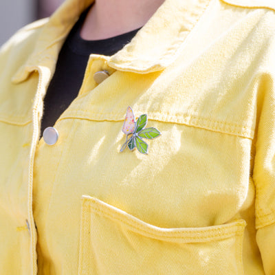 Stained glass chestnut blossom pin on a yellow jacket