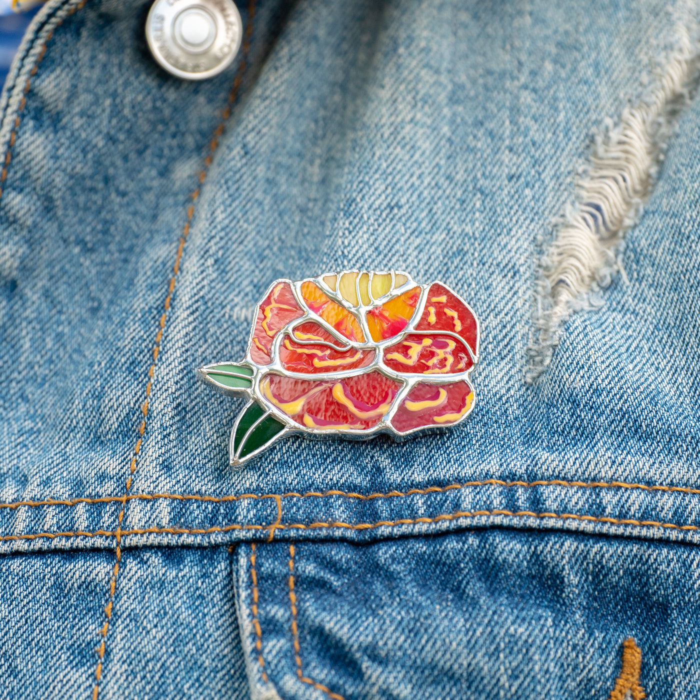 Marigold brooch of stained glass on a jeans jacket