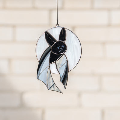 Bat with grey wings on the white moon window hanging of stained glass