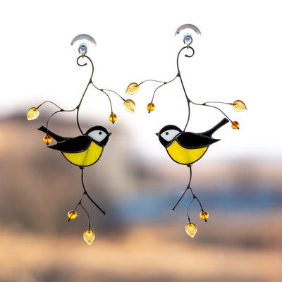 Two stained glass black chickadees looking at each other