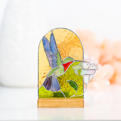 Zoomed stained glass panel in a wooden base depicting hummingbird