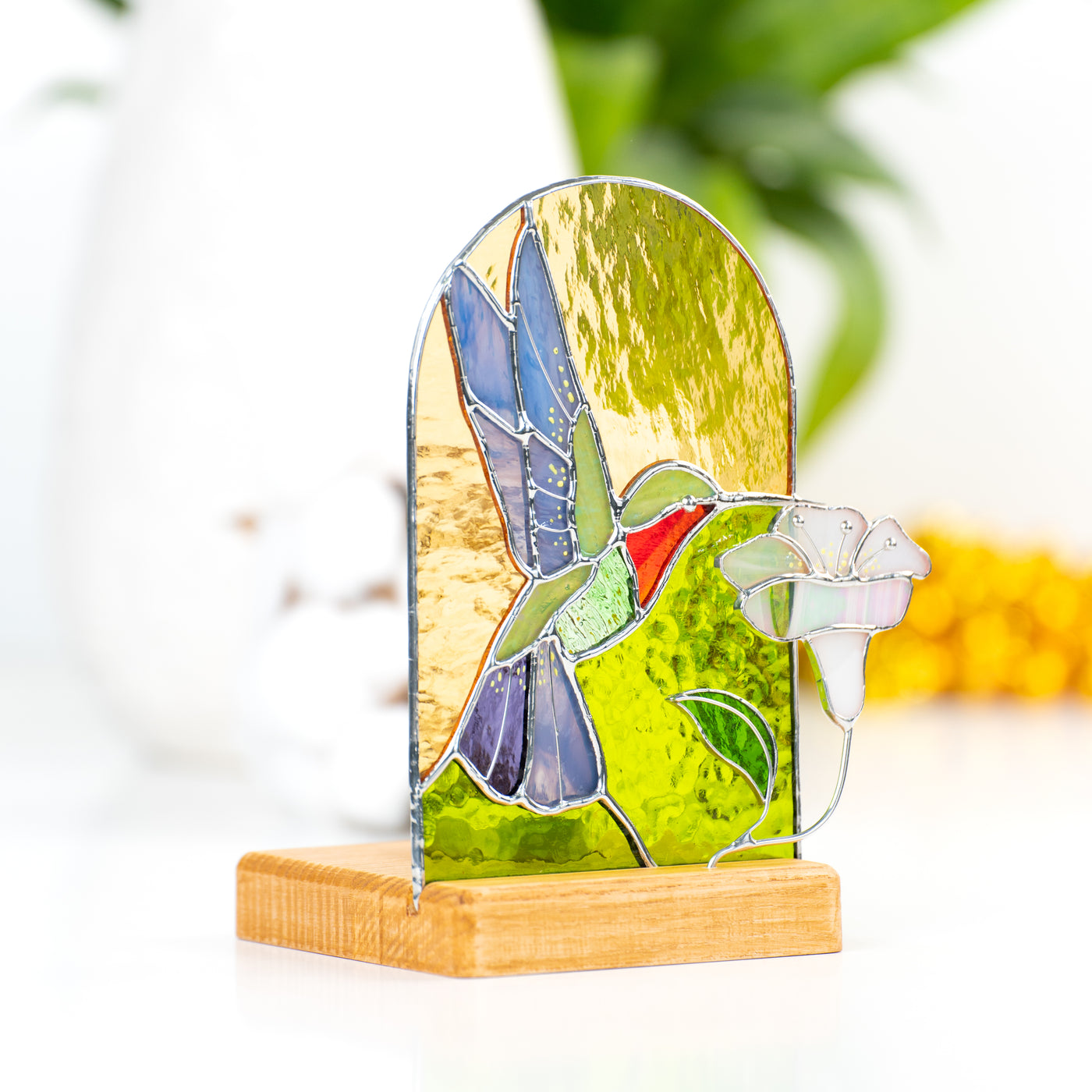 Side-view of a stained glass hummingbird panel in a wooden base