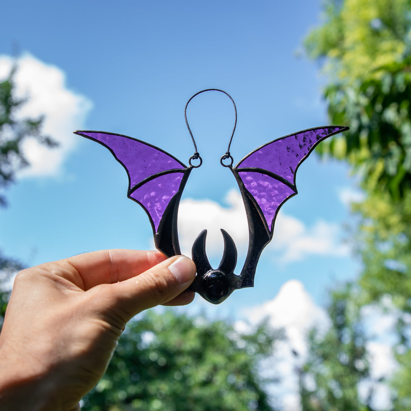 Suncatcher of a stained glass bat with purple wings