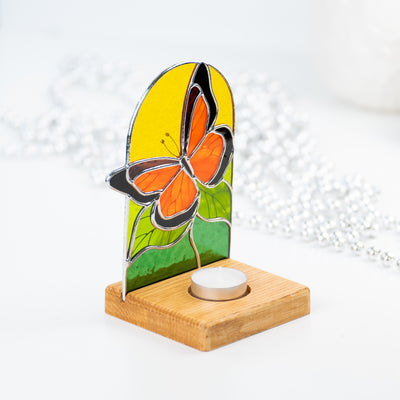 Stained glass monarch butterfly panel in a wooden base from behind