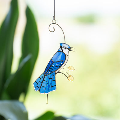 Stained glass blue jay bird sitting on the branch 