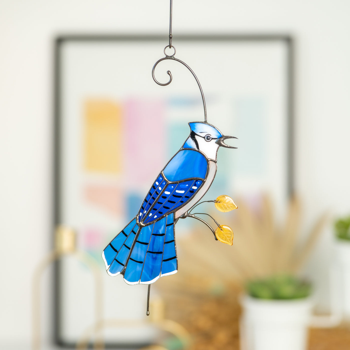 Stained glass window hanging of a blue jay with feathery tail