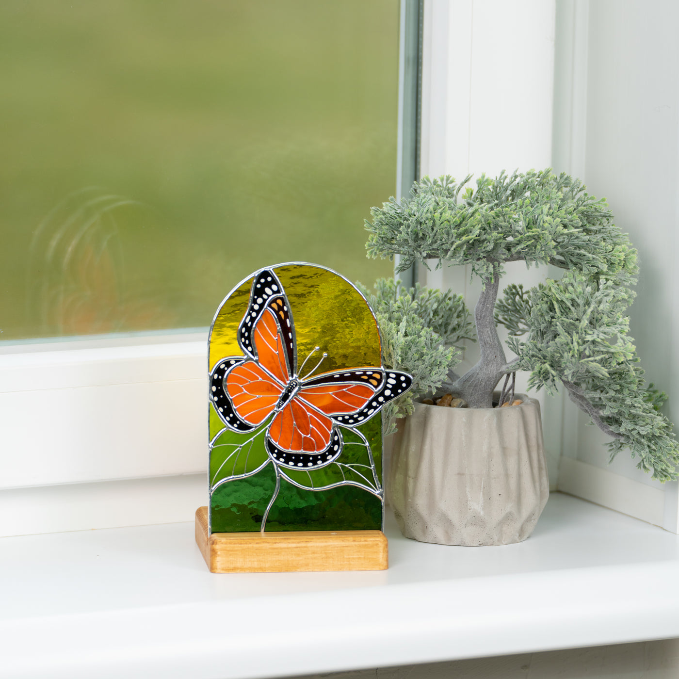 Stained glass monarch butterfly panel in a wooden base in interior