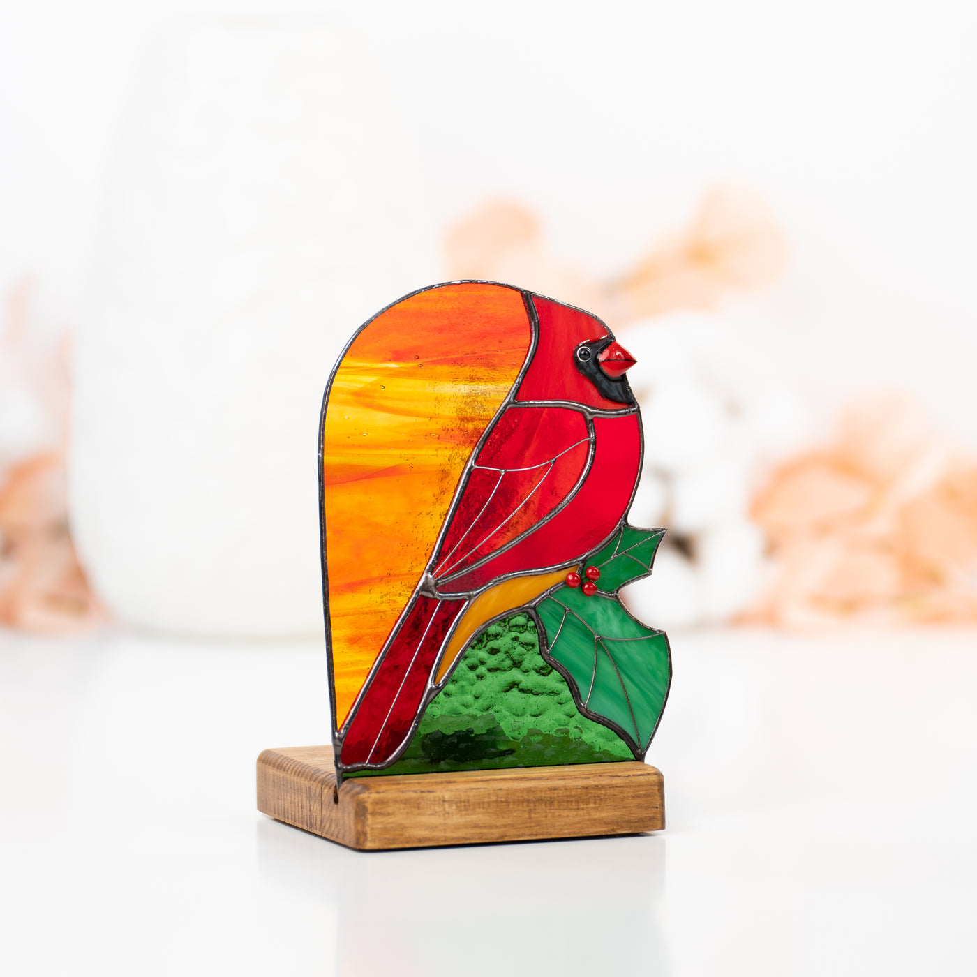 Candle-lit red cardinal with the leaf panel of stained glass
