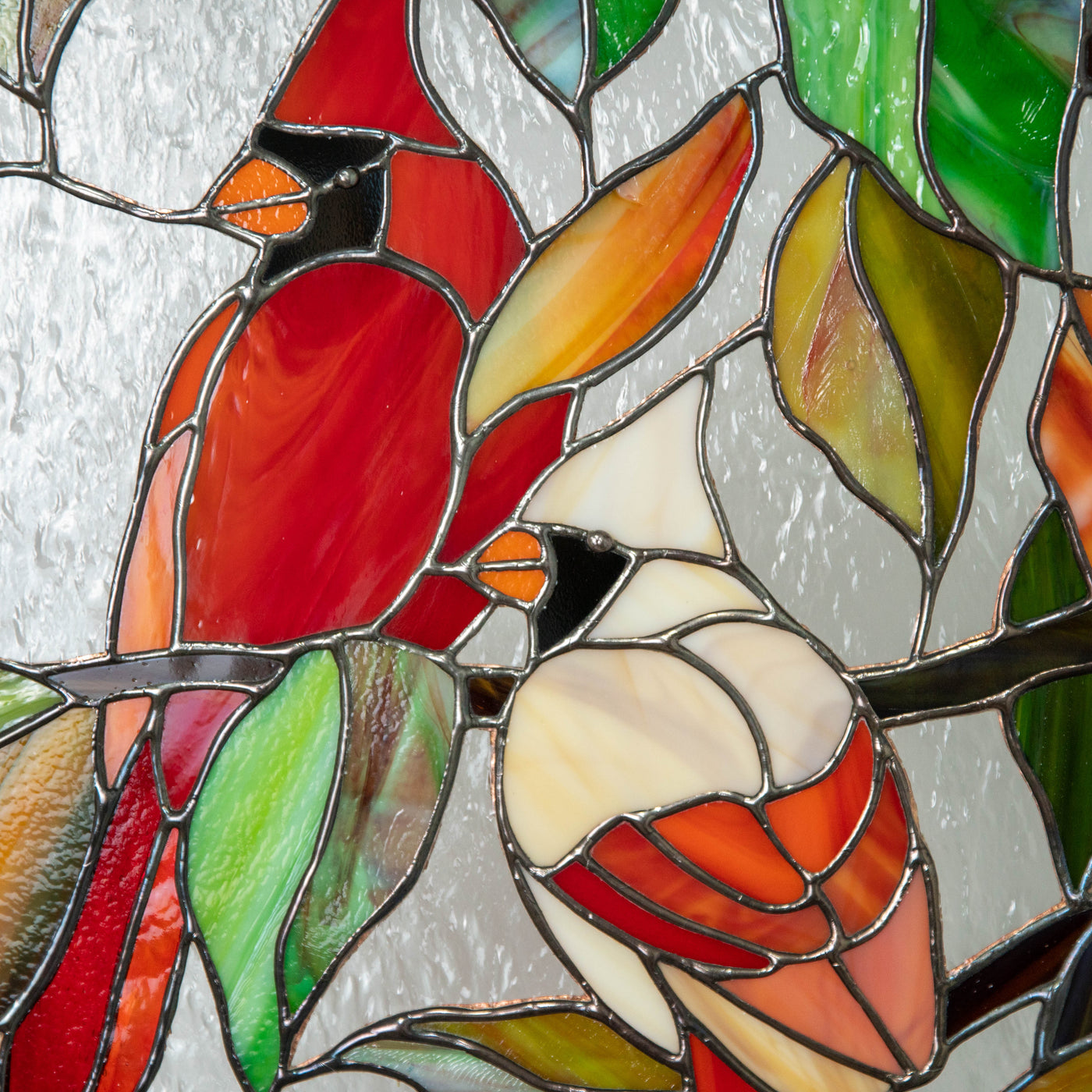 Zoomed stained glass window hanging of couple of cardinals