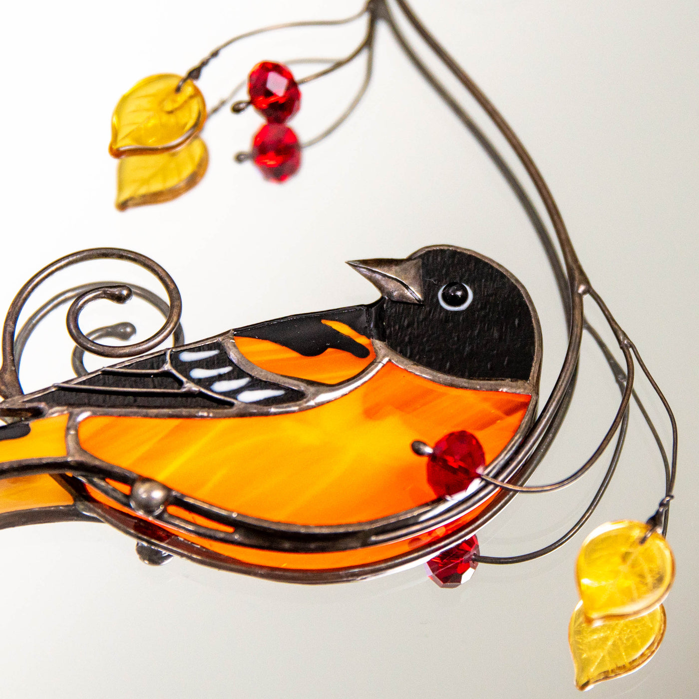 Zoomed stained glass suncatcher of Baltimore oriole bird