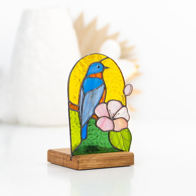 Stained glass candle-lit panel in a wooden base depicting bluebird and pink flower