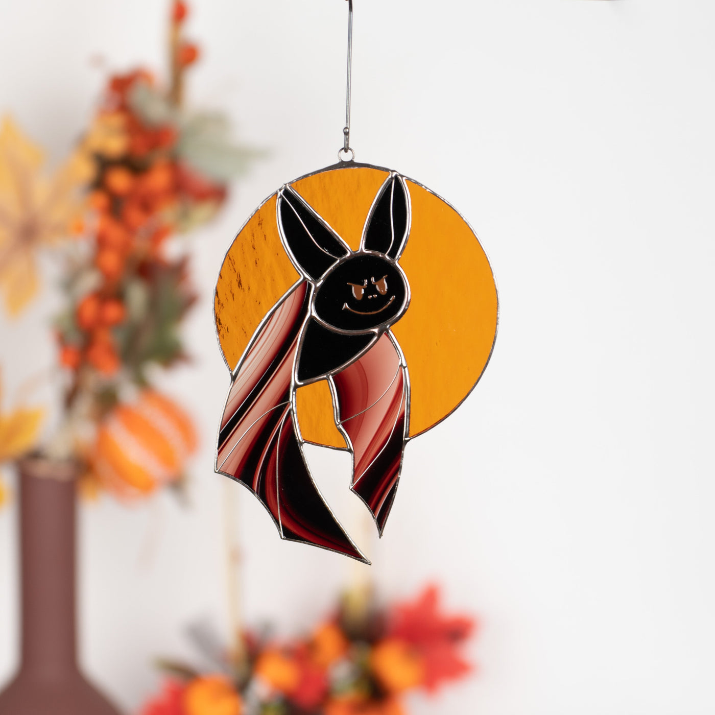 Stained glass Halloween black bat with brown wings on orange moon window hanging 