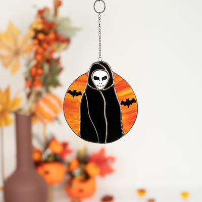 Stained glass Halloween window hanging of the Grim Reaper with the orange moon and bats on the background 