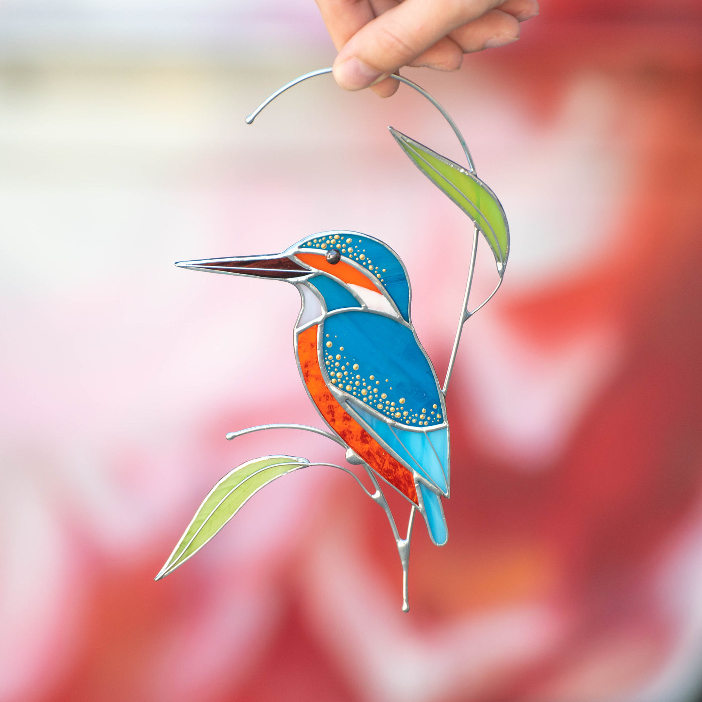 Stained glass kingfisher looking left on the branch with stained glass leaves suncatcher