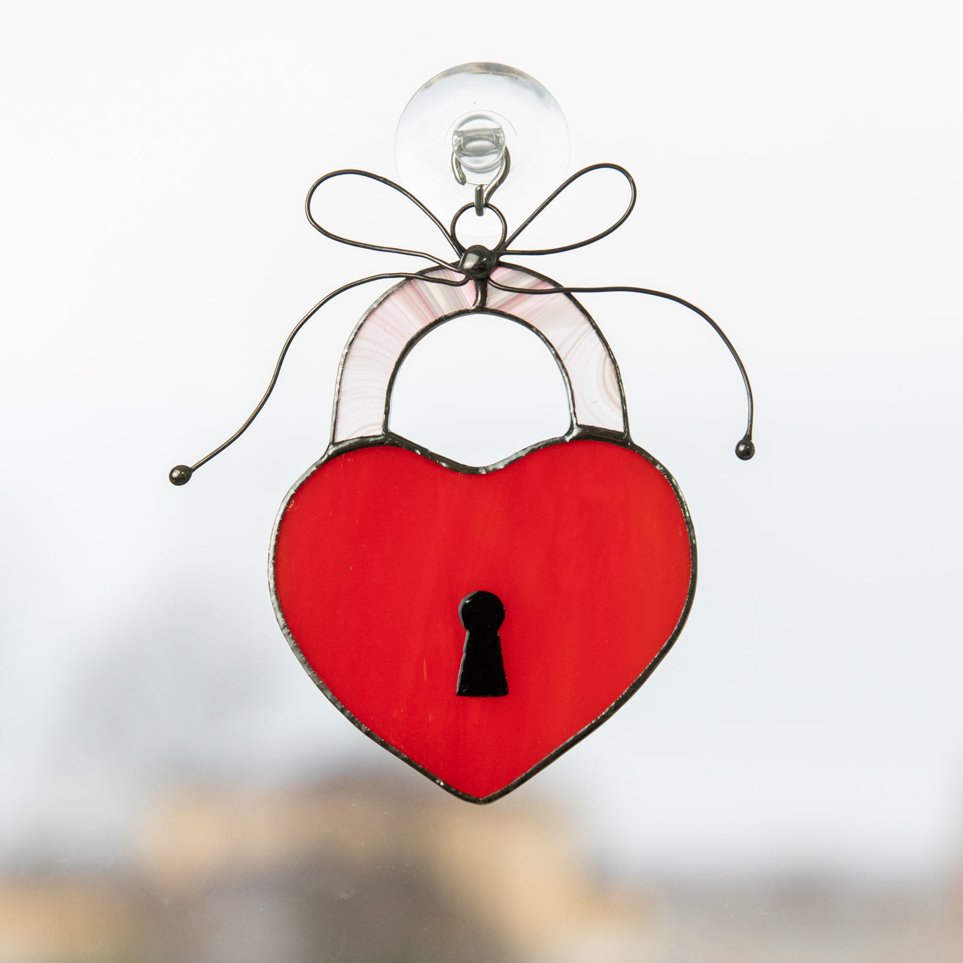 Stained glass suncatcher of a red heart with the key lock painted on it