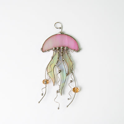 Window hanging of a stained glass pink jellyfish with iridescent tentacles