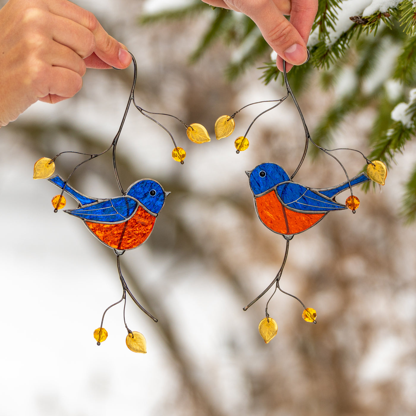 Stained glass bluebirds sitting on the branch window hanging