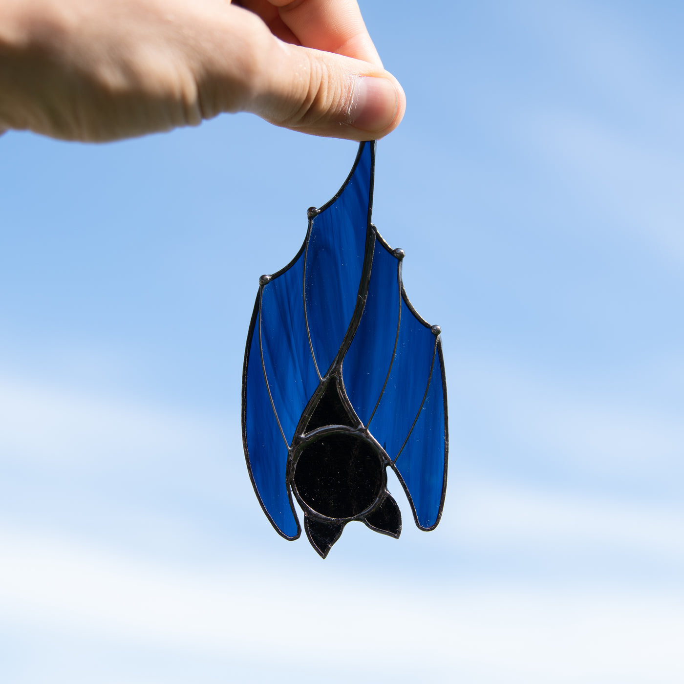 Window hanging of a stained glass sleeping blue bat 