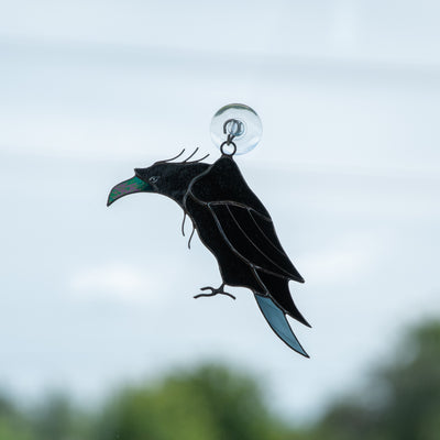 Suncatcher of a stained glass raven with nacre pecker