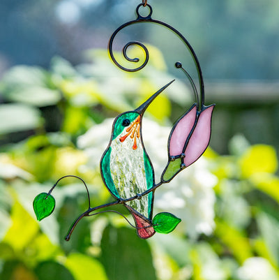 Stained glass hummingbird on the branch with pink flower suncatcher