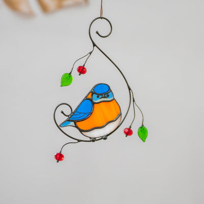 Stained glass bluebird with belly sitting on the branch with leaves and berries suncatcher