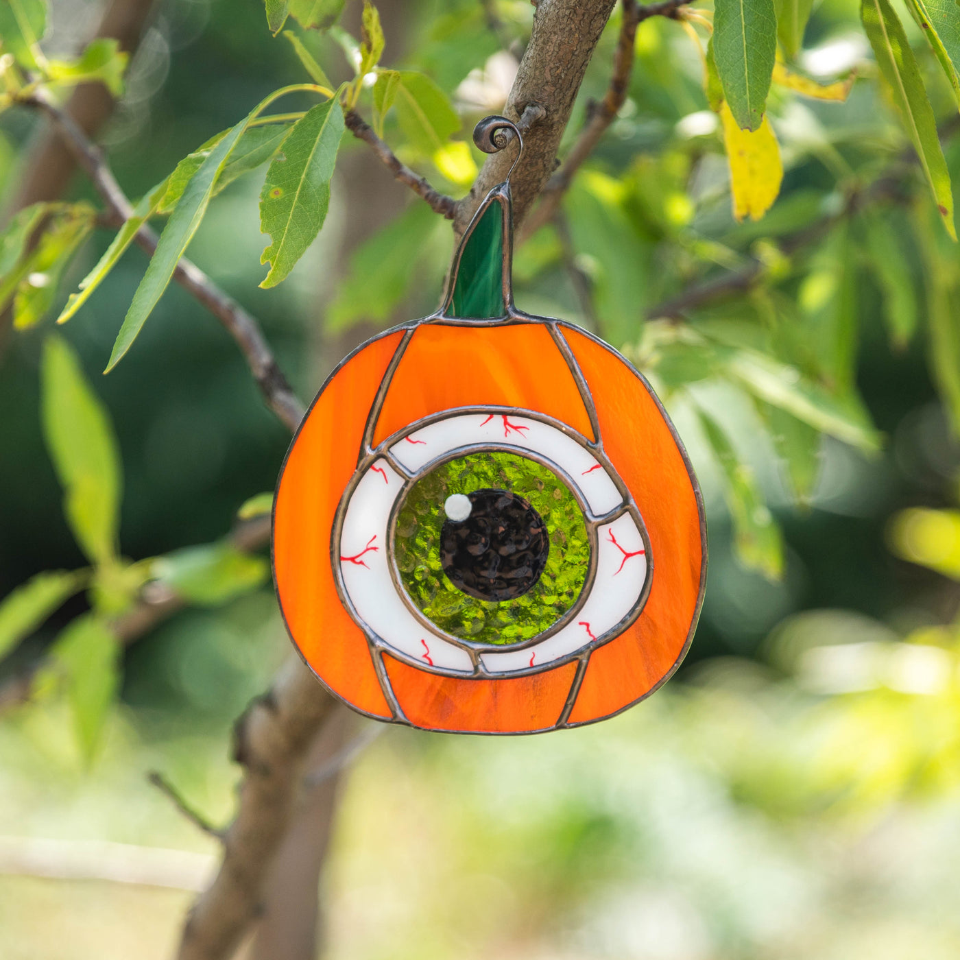 Stained glass pumpkin with the green eye inside suncatcher