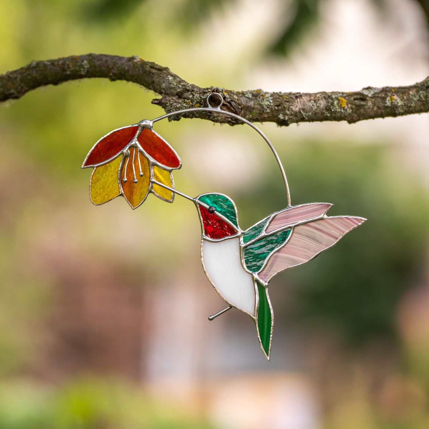 Bright stained glass hummingbird with pink and turquoise wings suncatcher