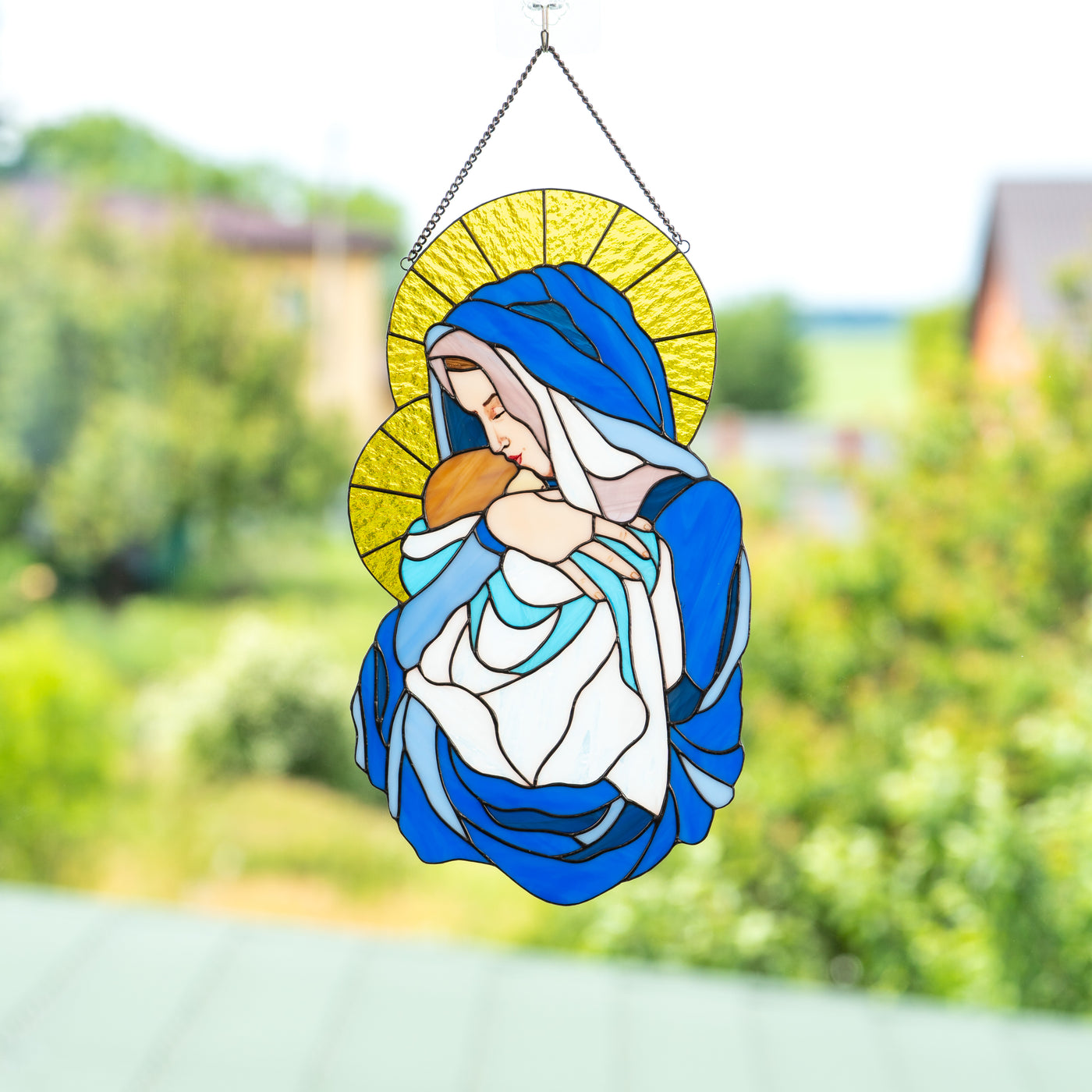 Stained glass window hanging of Virgin Mary with Jesus Christ in blue and yellow colours 